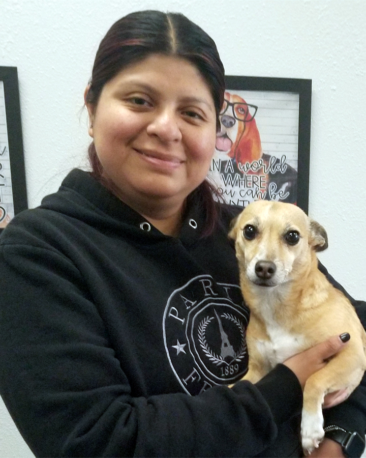 Meet Mindy, a professional dog walker with Tailored Pet Services LLC in Everett, WA 98203, pictured smiling while holding a small tan dog. Mindy provides personalized dog walking services focused on exercise, sensory exploration, enrichment, and building trusting relationships with dogs. Her lifelong love of animals and passion for outdoor adventures help make every walk a positive experience.